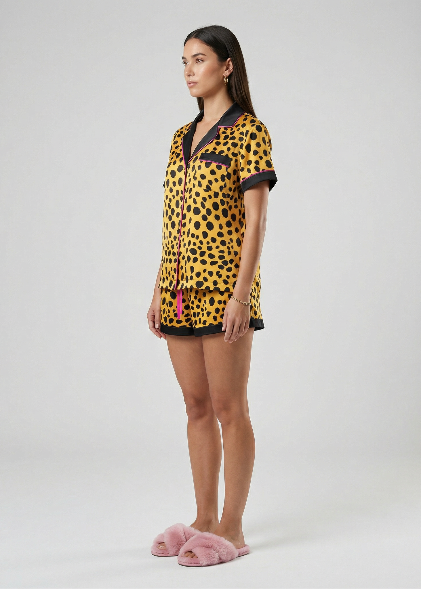 Woman wearing a leopard print outfit with pink slippers on a white background